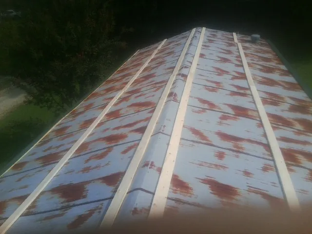 Rusted metal roof panels with new wood purlins before replacement — Storm Damage Roof Repair in Colliersville by Roofing Brothers