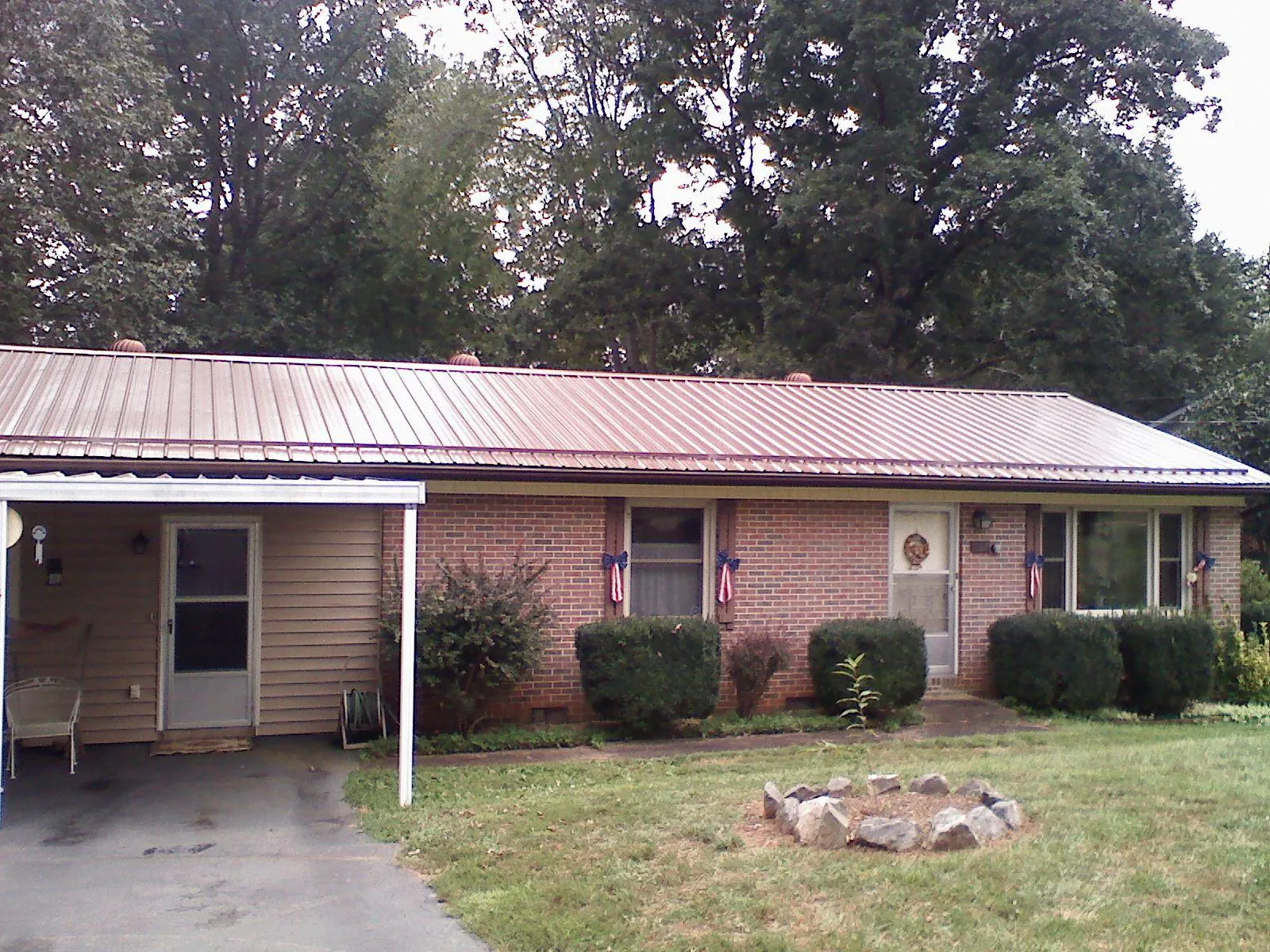 Bronze metal roof and carport on a brick ranch home — Roof Repair work by our crew in Colliersville